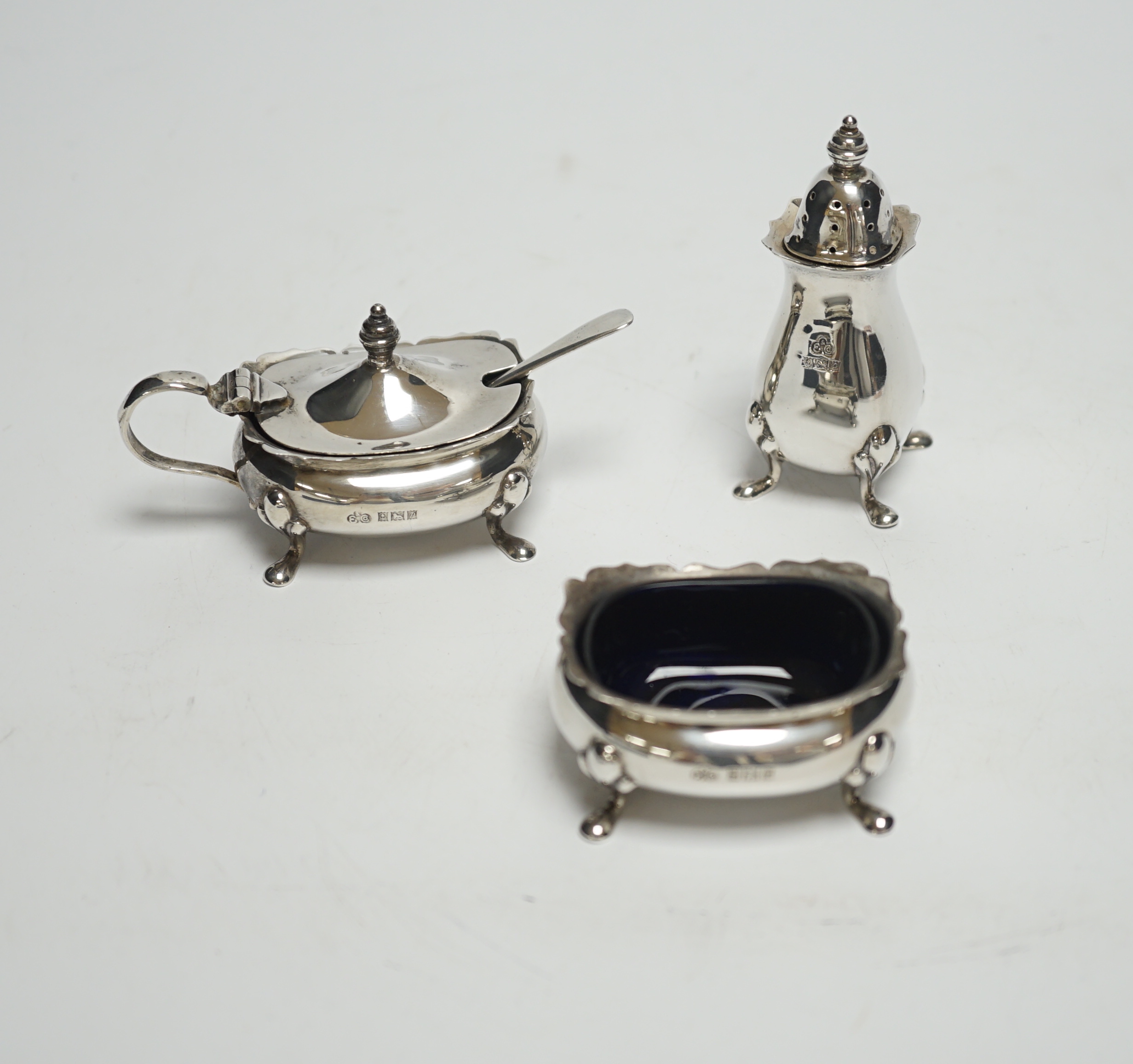 A Elizabeth II three piece silver condiment set by Elkington & Co, Birmingham, 1964/65, with associated silver spoon.